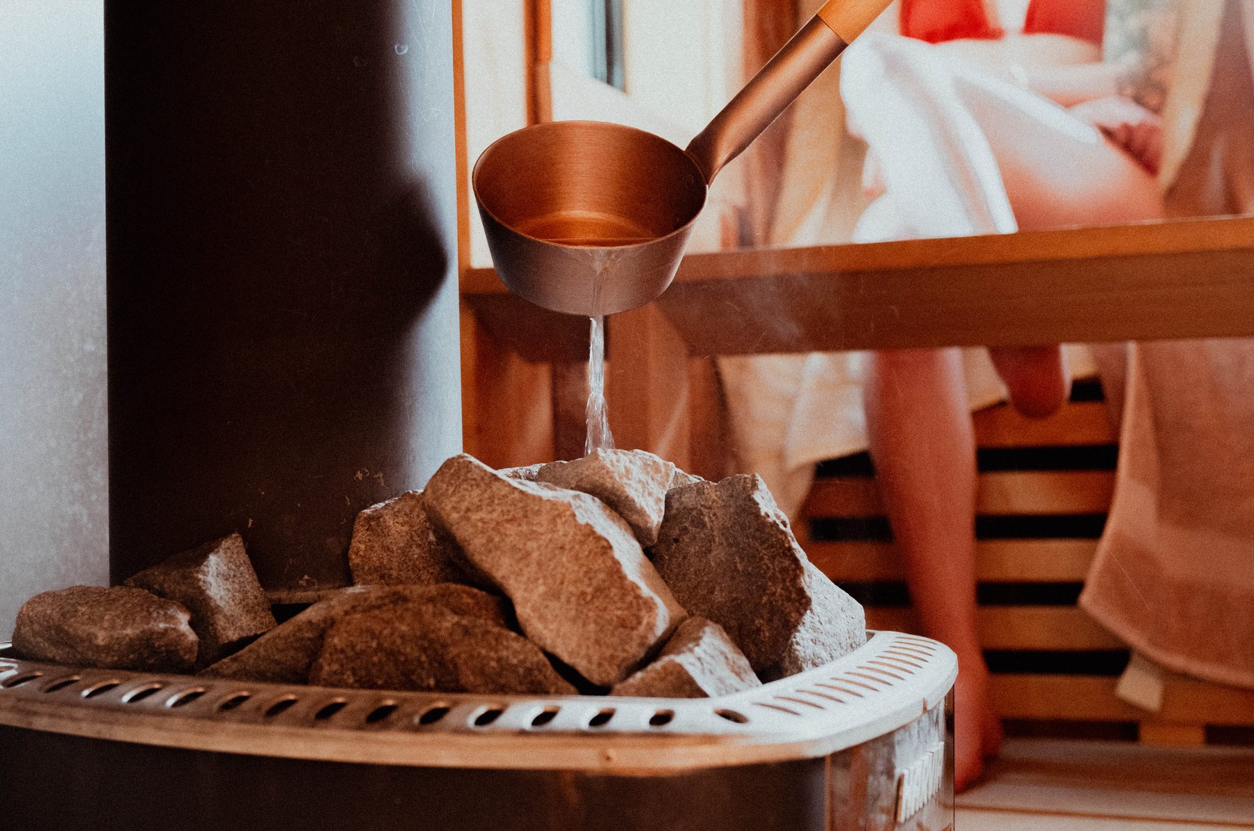 L&ouml;yly: water poured from a copper ladle over the hot stones of a sauna stove